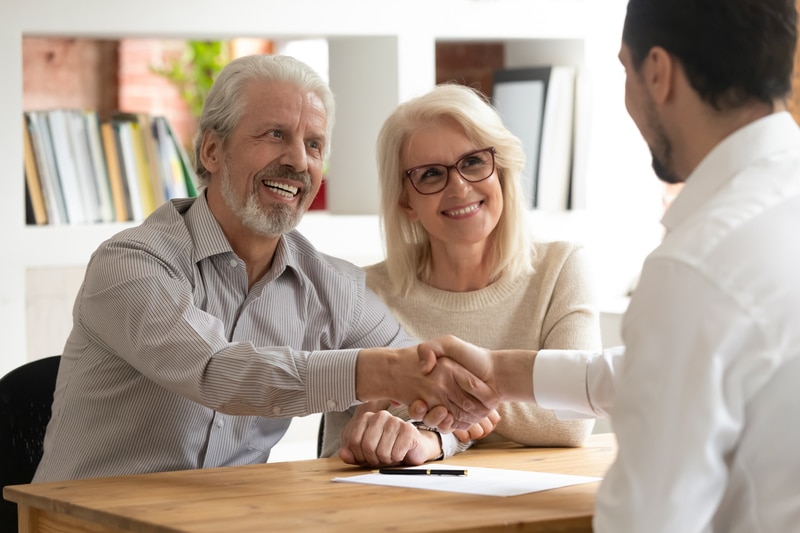 A couple signing a ghostwriting services contract with a ghostwriter.