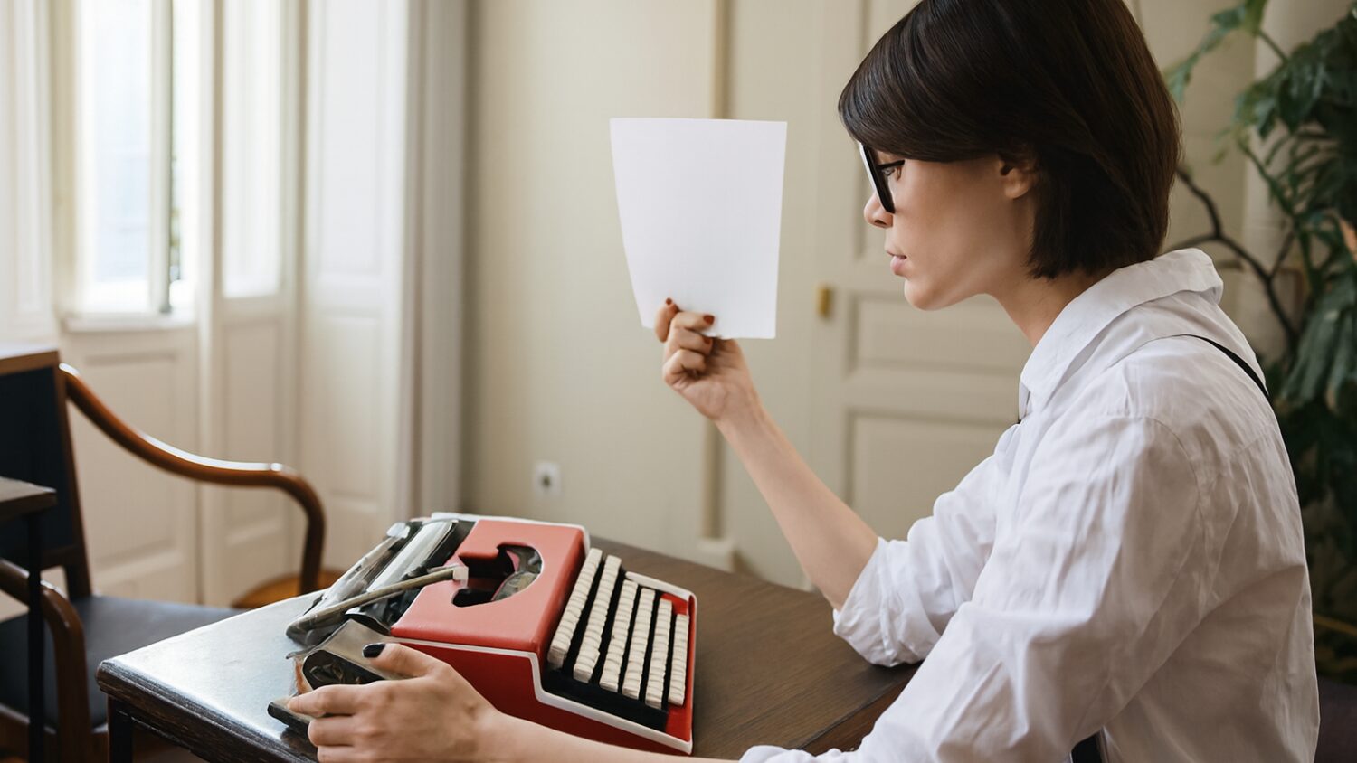 Side view of authoress with paper and typewriter